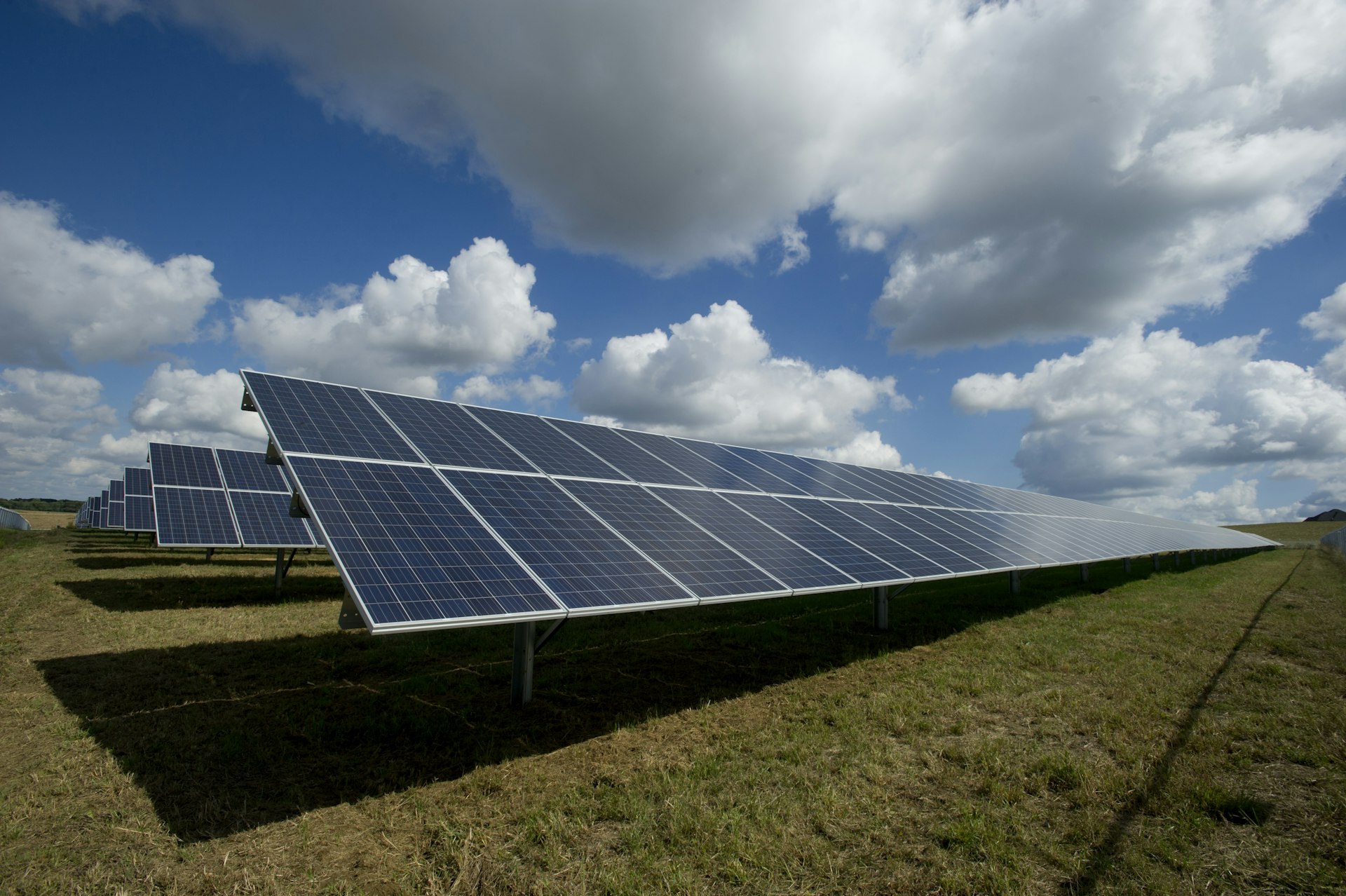 Solar panels in a field with mountains at sunrise